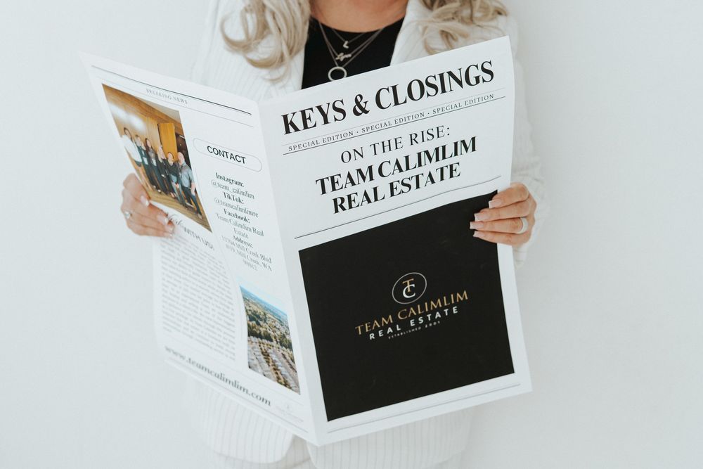 Person holding a real estate magazine titled 'Keys & Closings' featuring property listings and market updates.