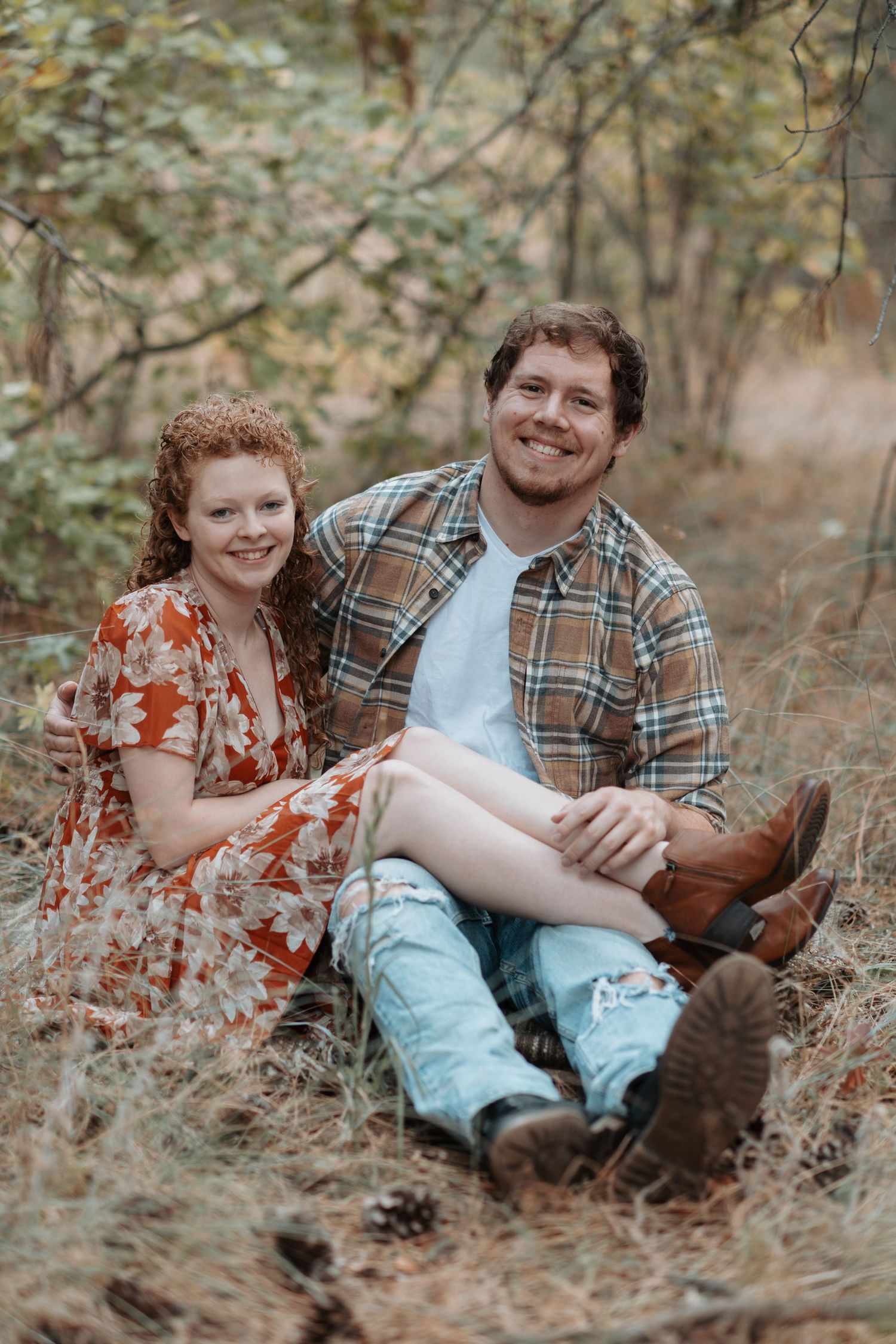 A playful pose for a couple in Post Falls, Idaho during their engagement session at Kiwanis Park. Fall foliage surrounds them.