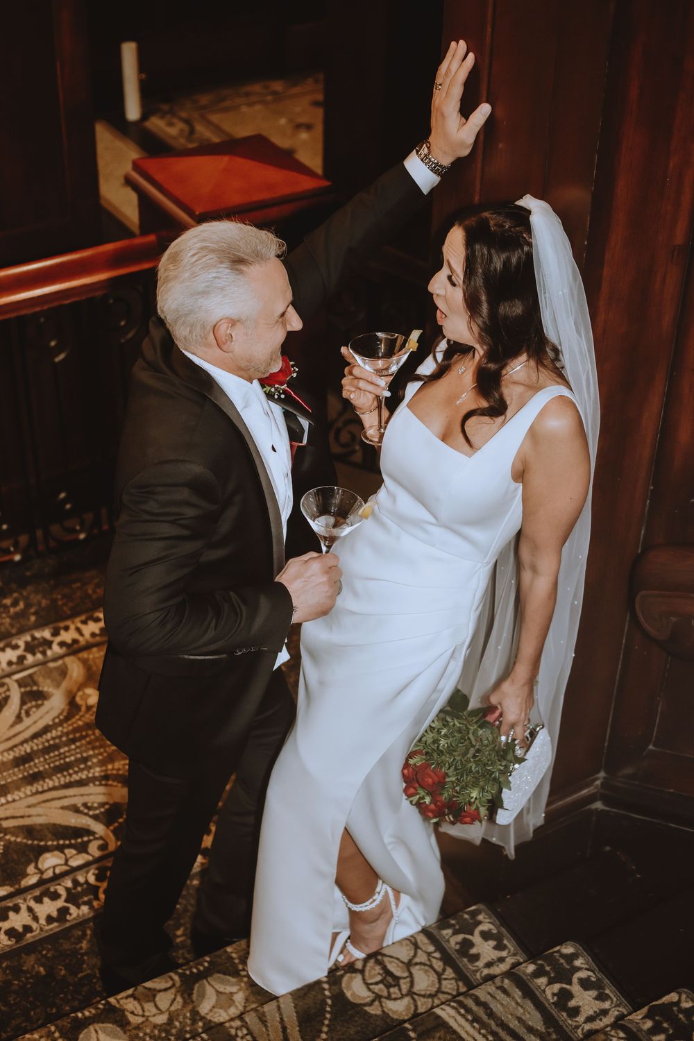 A couple in wedding attire shares an intimate dance moment on a patterned carpet during their reception celebration.