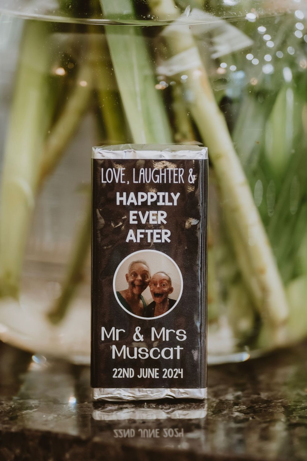 Glass wedding coasters with romantic text and teddy bear designs displayed outdoors with a blurred natural backdrop.