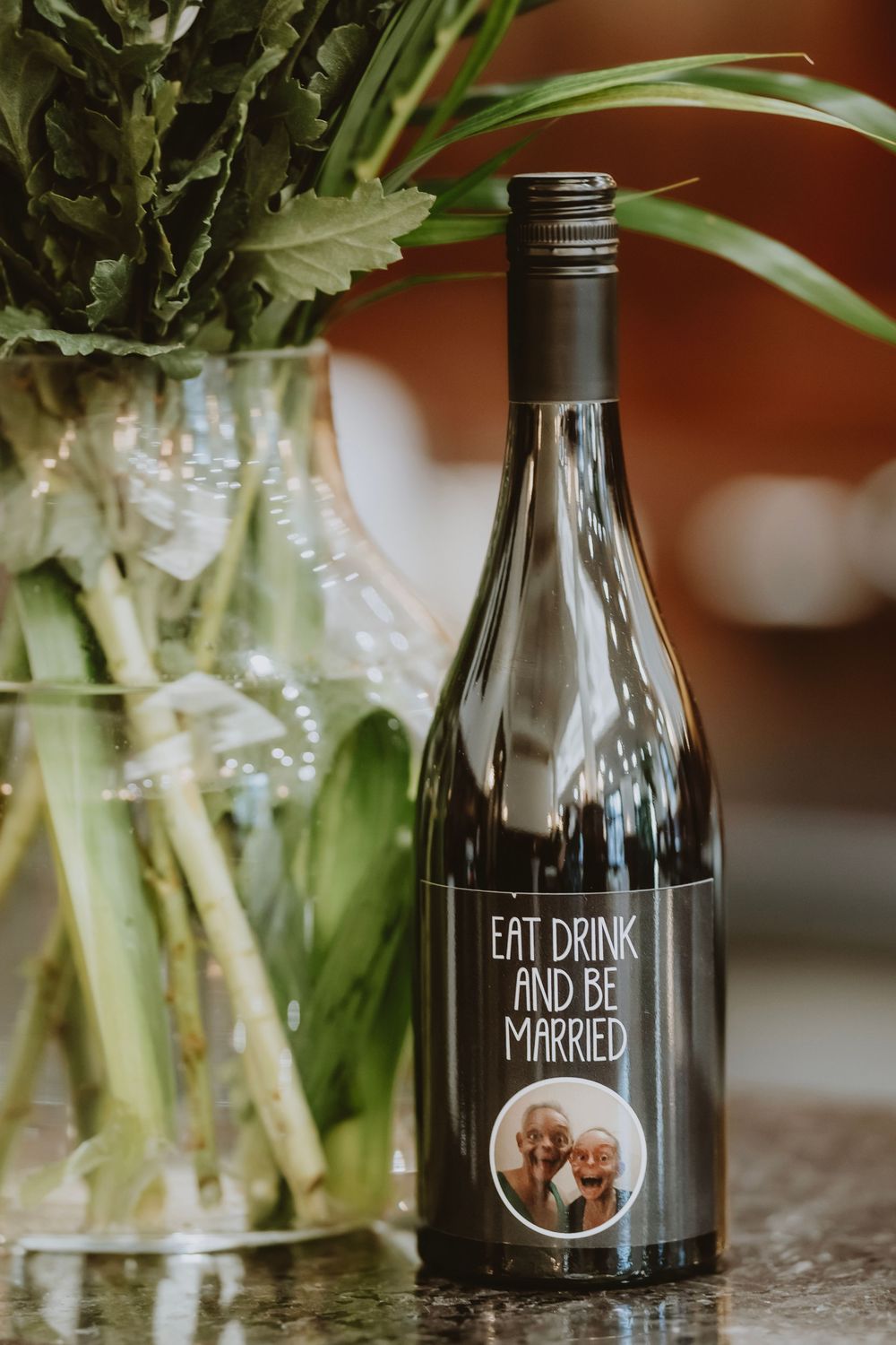 Glass bottles with custom wedding text and floral arrangements displayed in sequence for wedding decor photography.