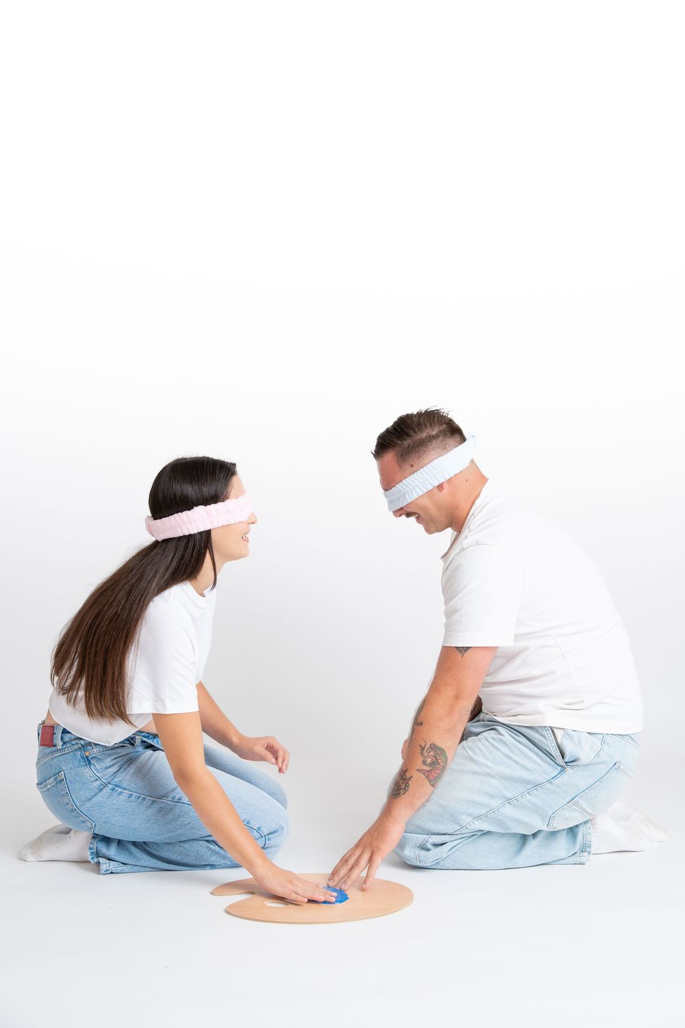 Person wearing white shirt and blue jeans sitting in progressive yoga poses against white background.