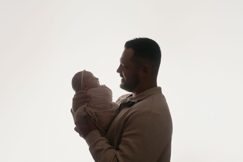 Backlit father and baby pose, taken by Jen Knightstep, Photographer