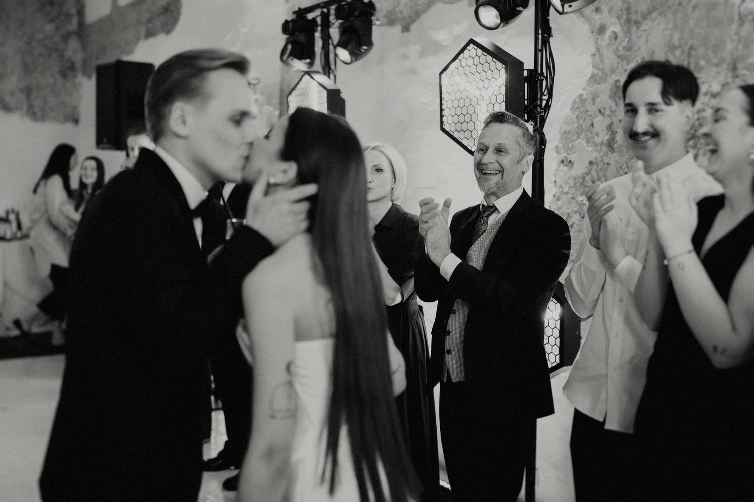 Black and white photo of wedding guests socializing at an elegant indoor reception.