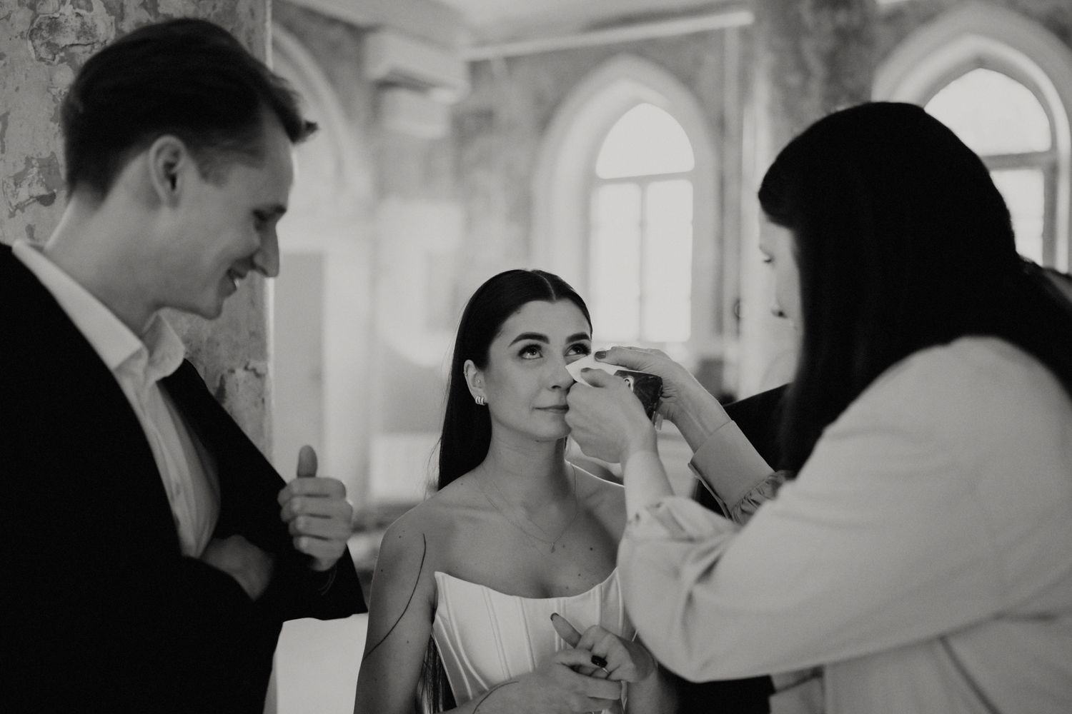 Candid moments captured during an indoor wedding reception in a historic building.