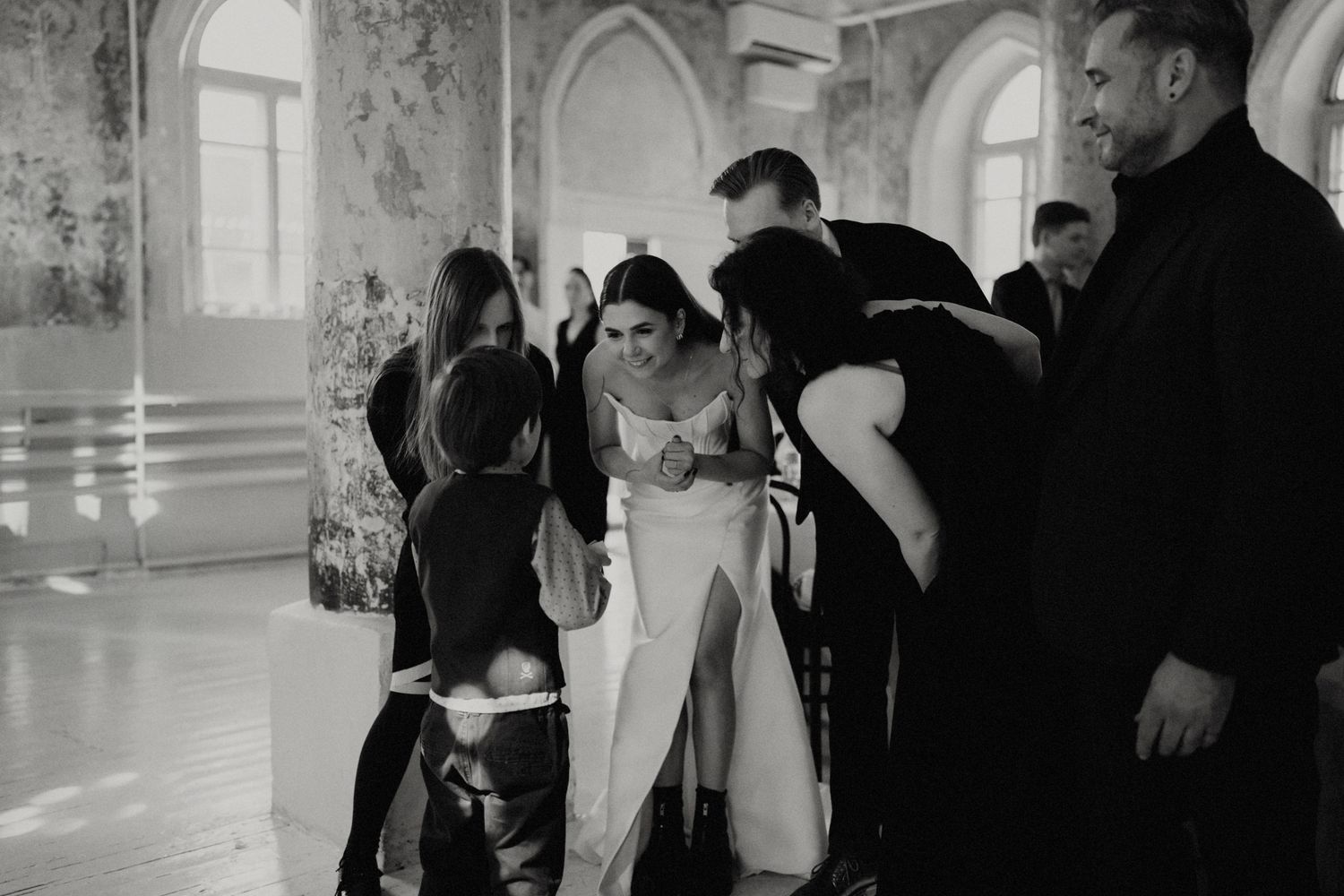 Black and white photo of guests mingling at an elegant indoor reception venue.
