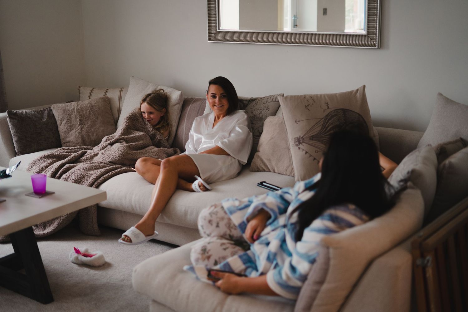 Family relaxing together on a comfortable gray couch in a cozy living room setting.