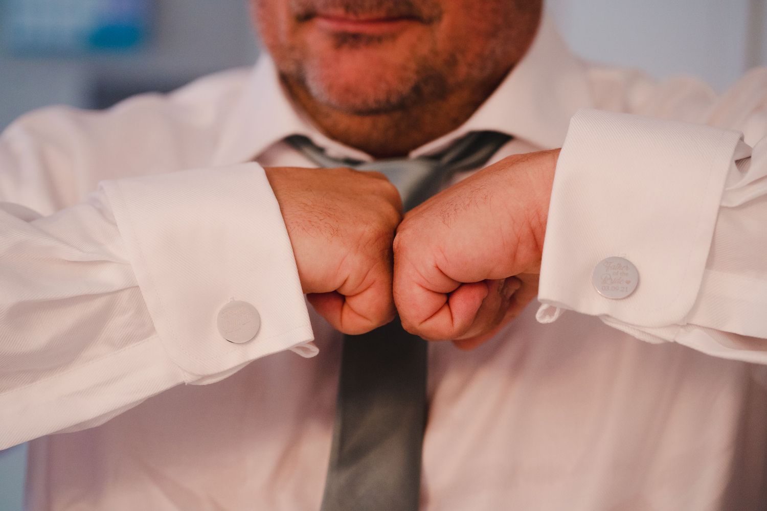 Close-up shots of someone adjusting formal white shirt cuffs and buttons.