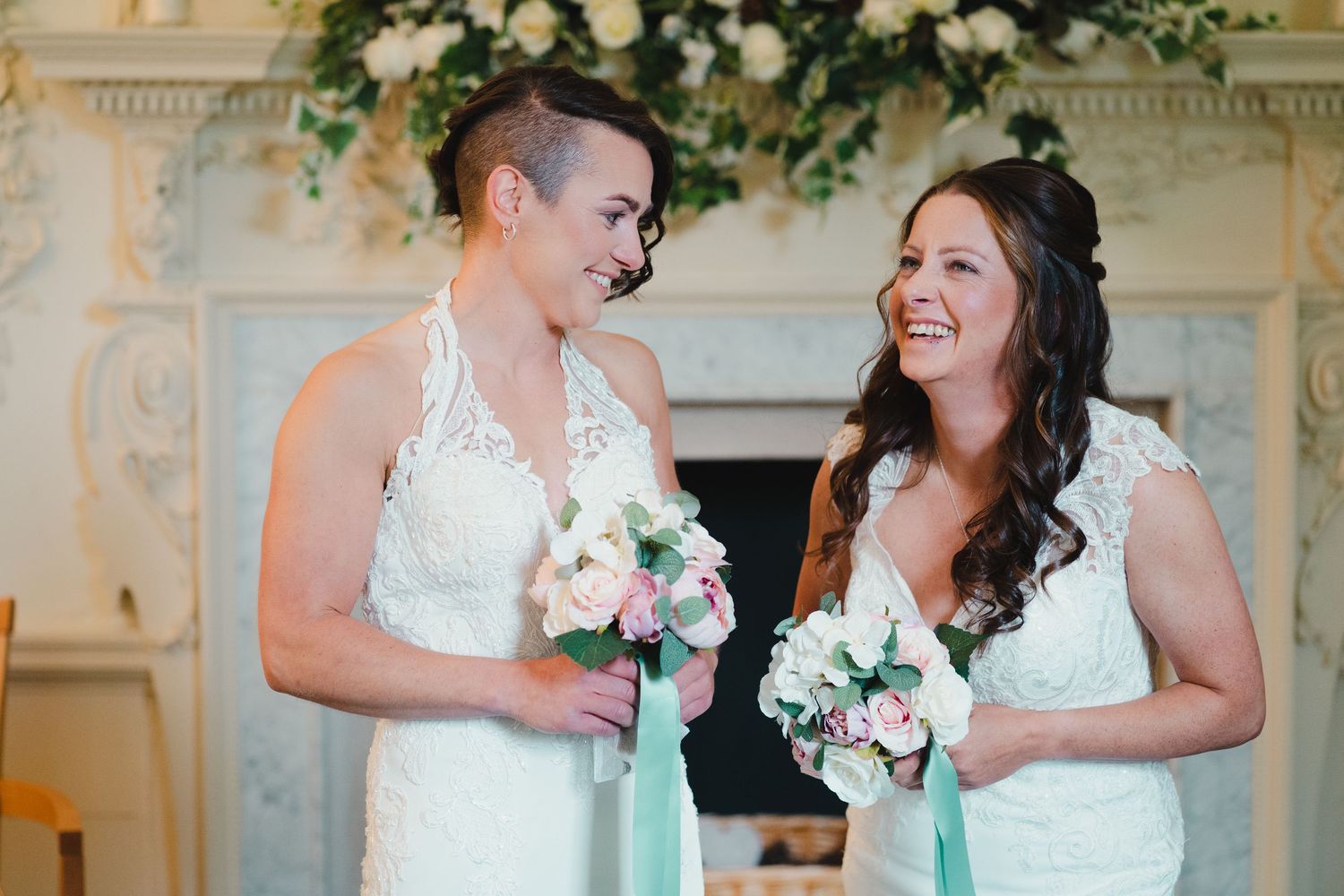 Wedding party members sharing joyful moments in an elegant venue with floral decorations.