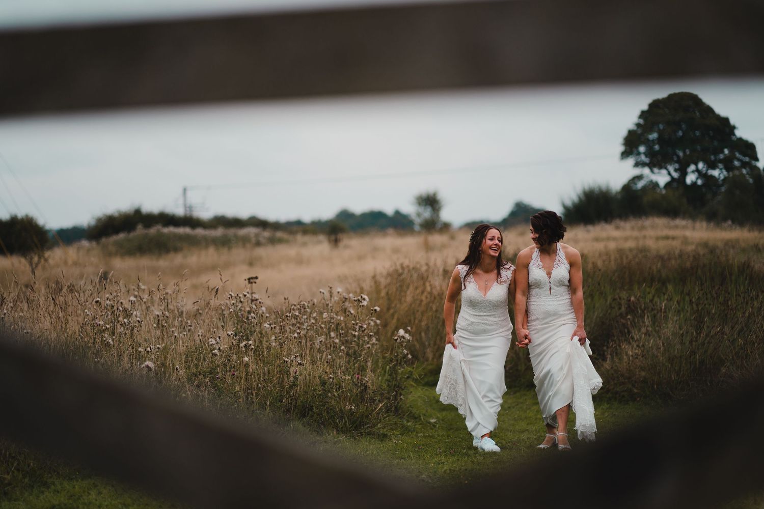 Artistic wide-angle view of figures in white walking through a rural landscape.