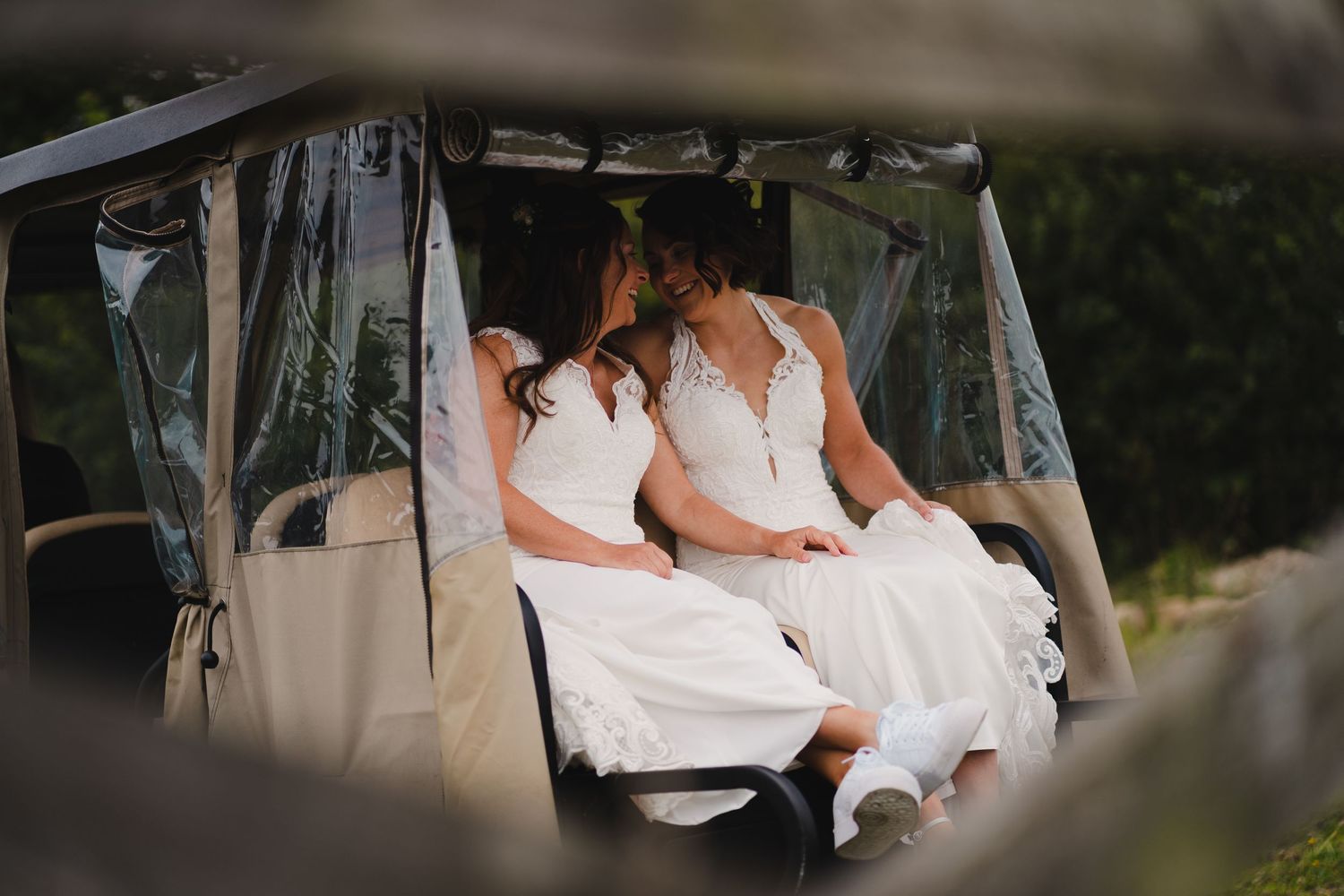 A couple seated outdoors together shares a tender moment in natural lighting.