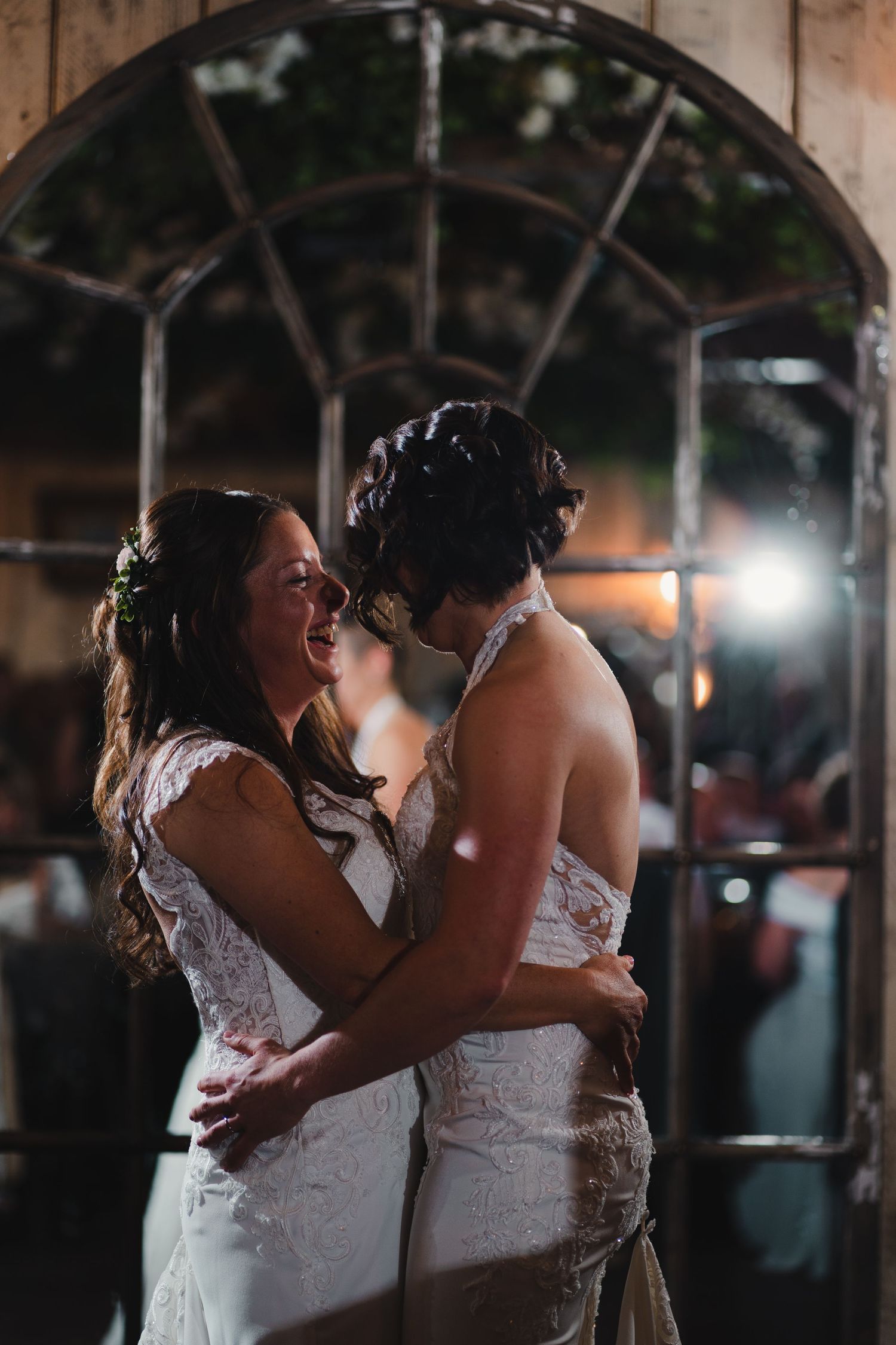 Intimate wedding dance sequence lit by fairy lights showing romantic moments between two brides in white dresses.