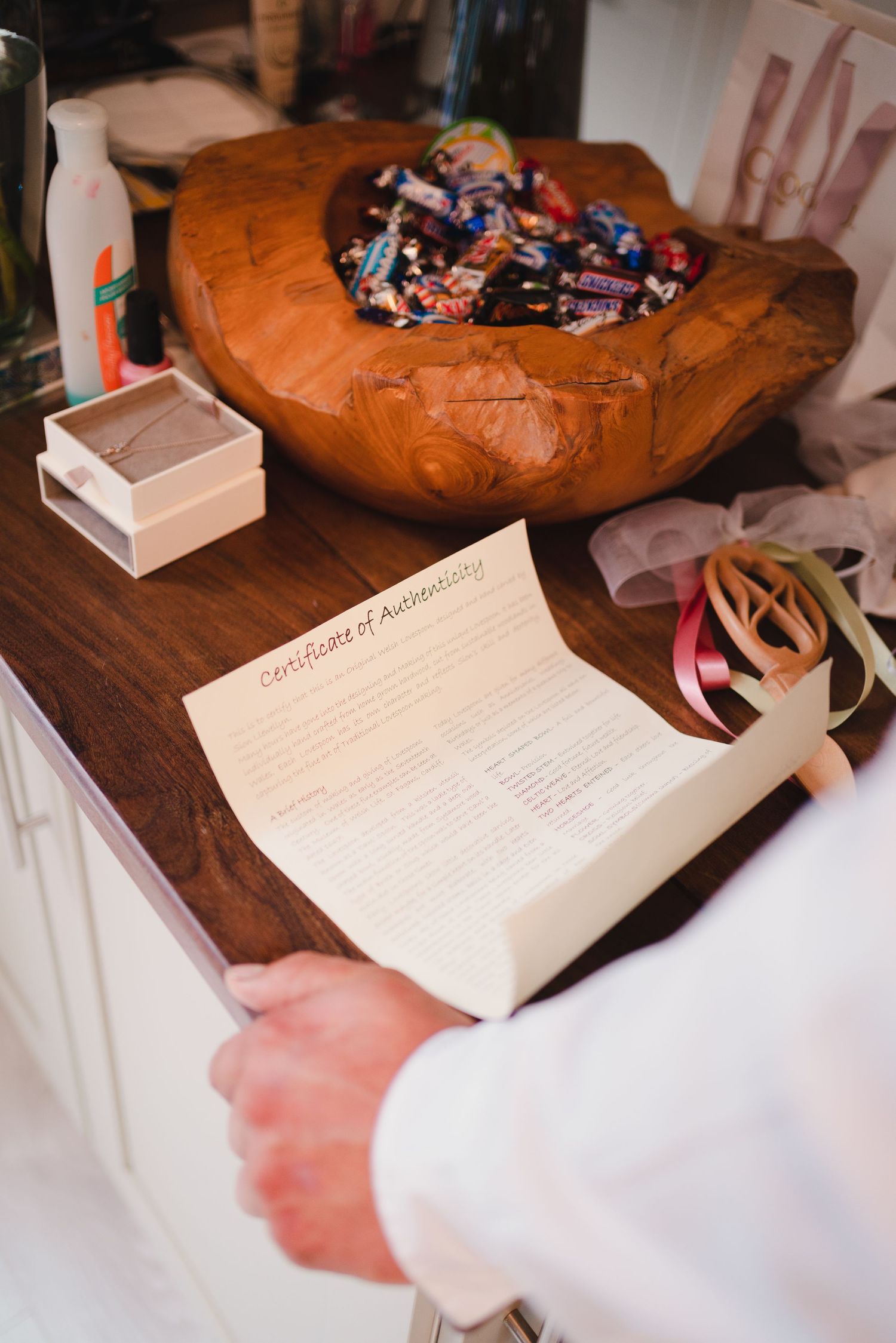 Series of close-up shots showing hands writing in a wedding guest book on wooden surface.