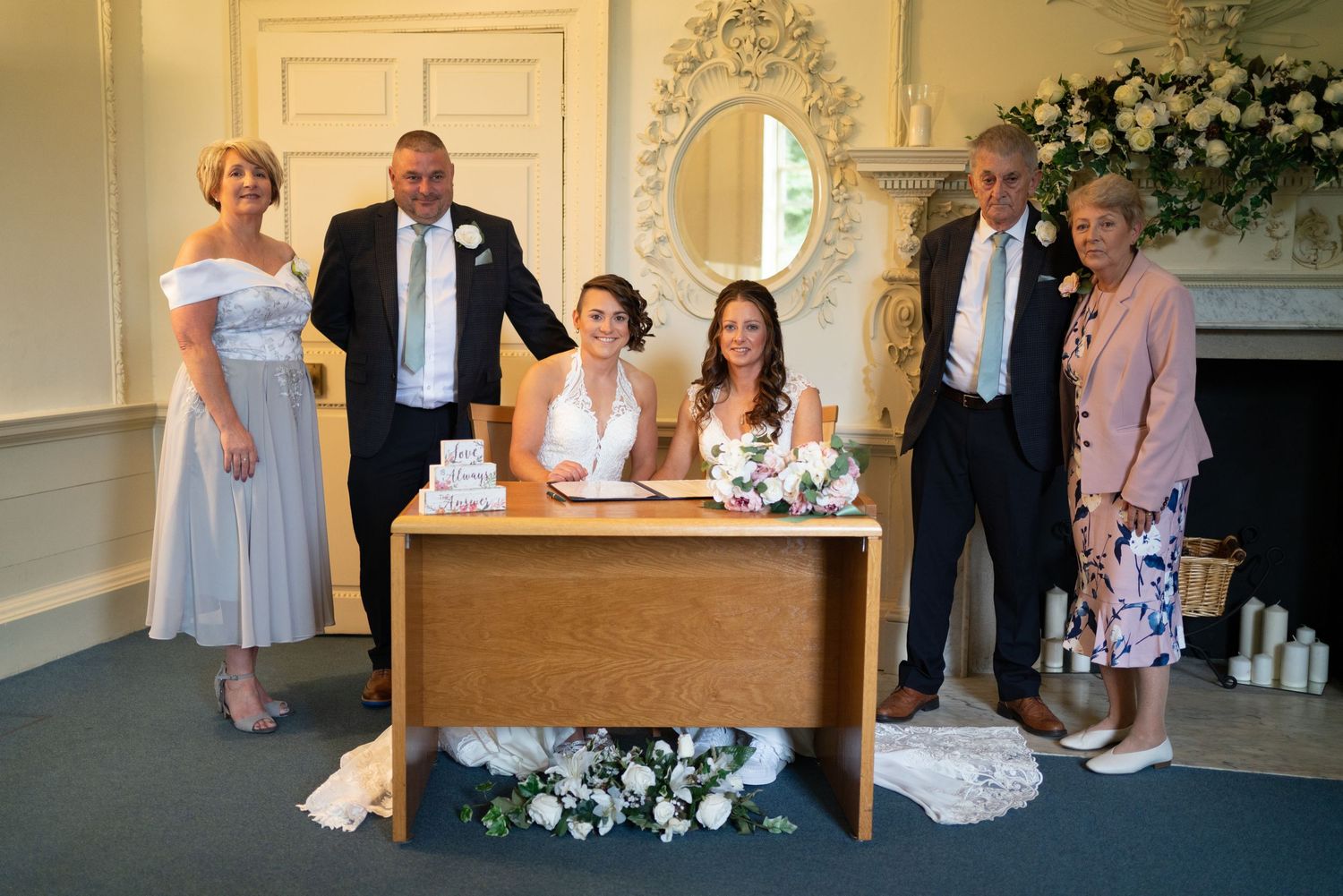 Elegant wedding reception venue with ornate decor, floral arrangements, and guests seated in formal attire.
