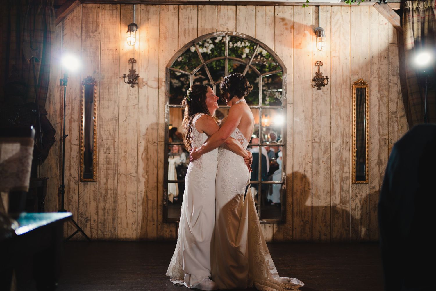 Rustic barn wedding venue with warm lighting and wooden walls creating an intimate atmosphere.