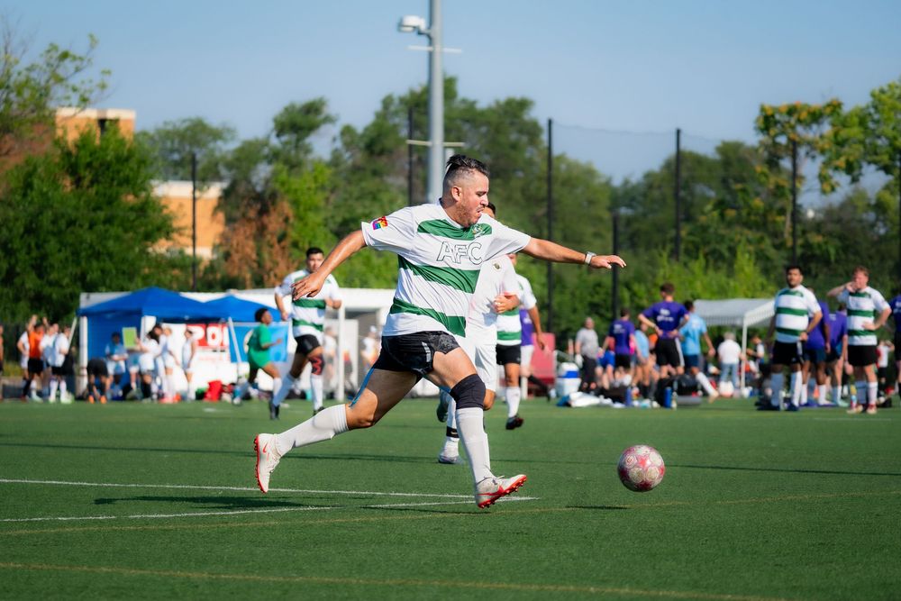 A soccer athlete dribbles the ball downfield