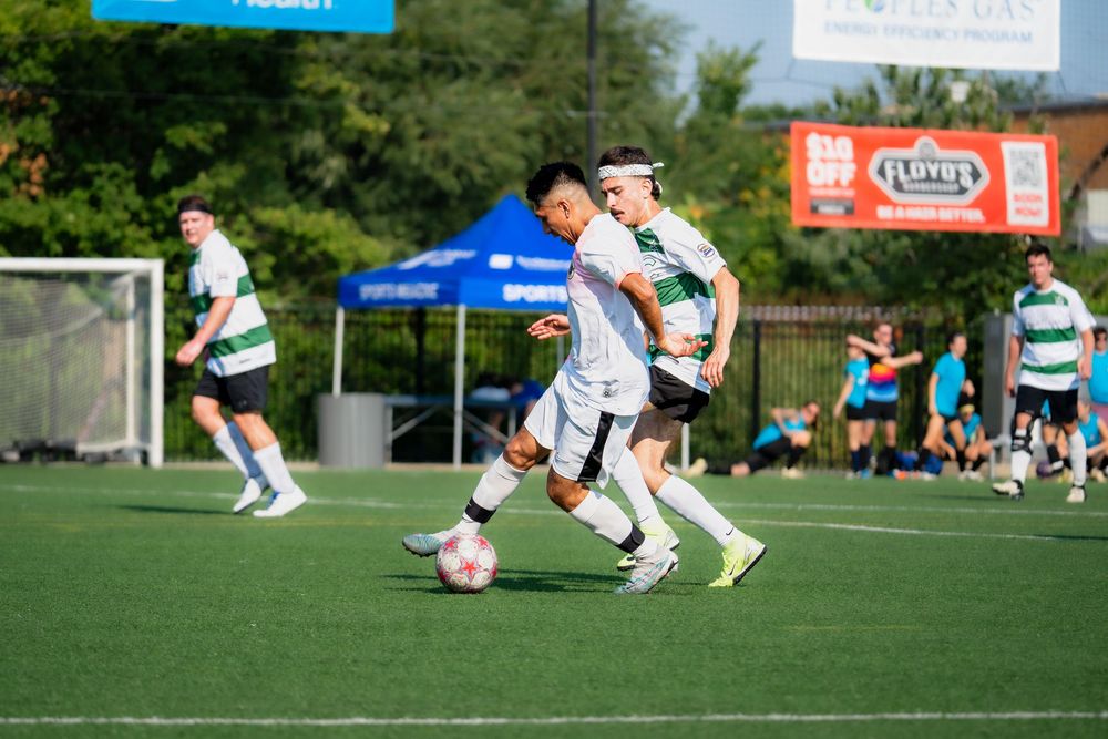 Two soccer athletes attempt to take control of the ball