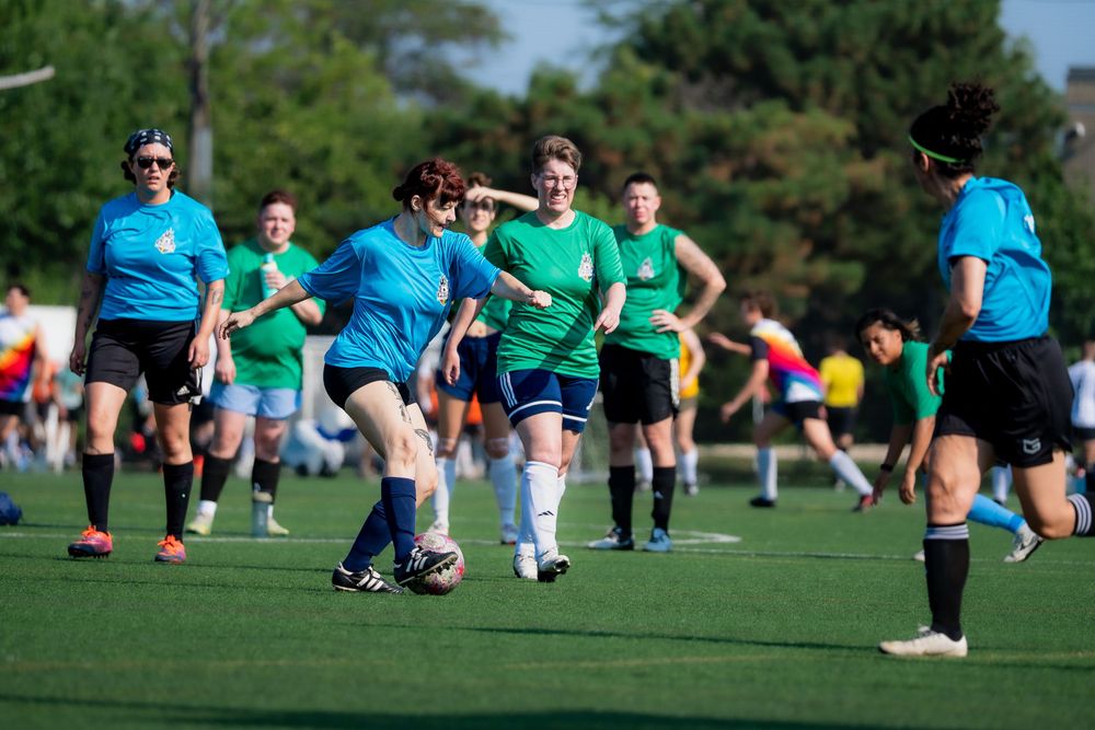A soccer athlete dribbles the ball downfield