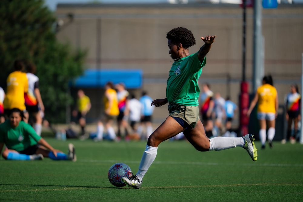 A soccer athlete dribbles the ball downfield