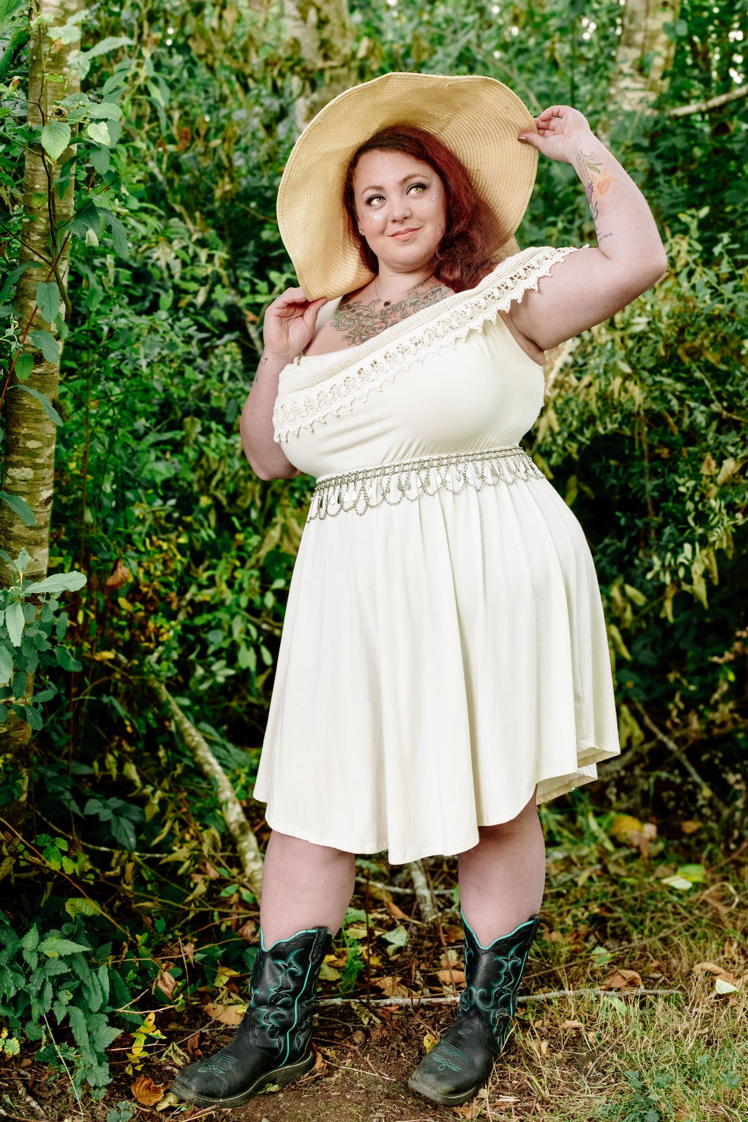 Confident portrait of model in cream dress and hat at The Pole Garden in Monroe WA.