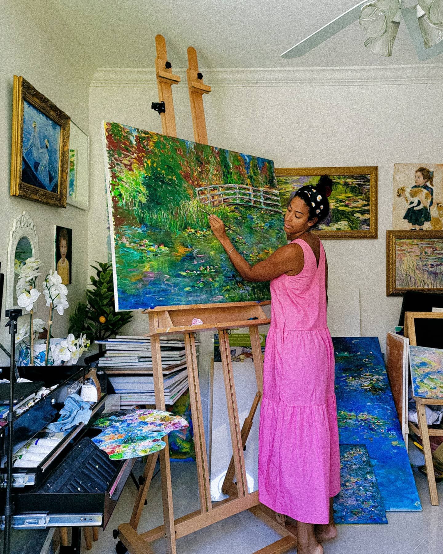 Vibrant painting of water lilies on a pond surrounded by drooping willow branches in rich greens and blues. Monet Kim ahonoukoun  legacy