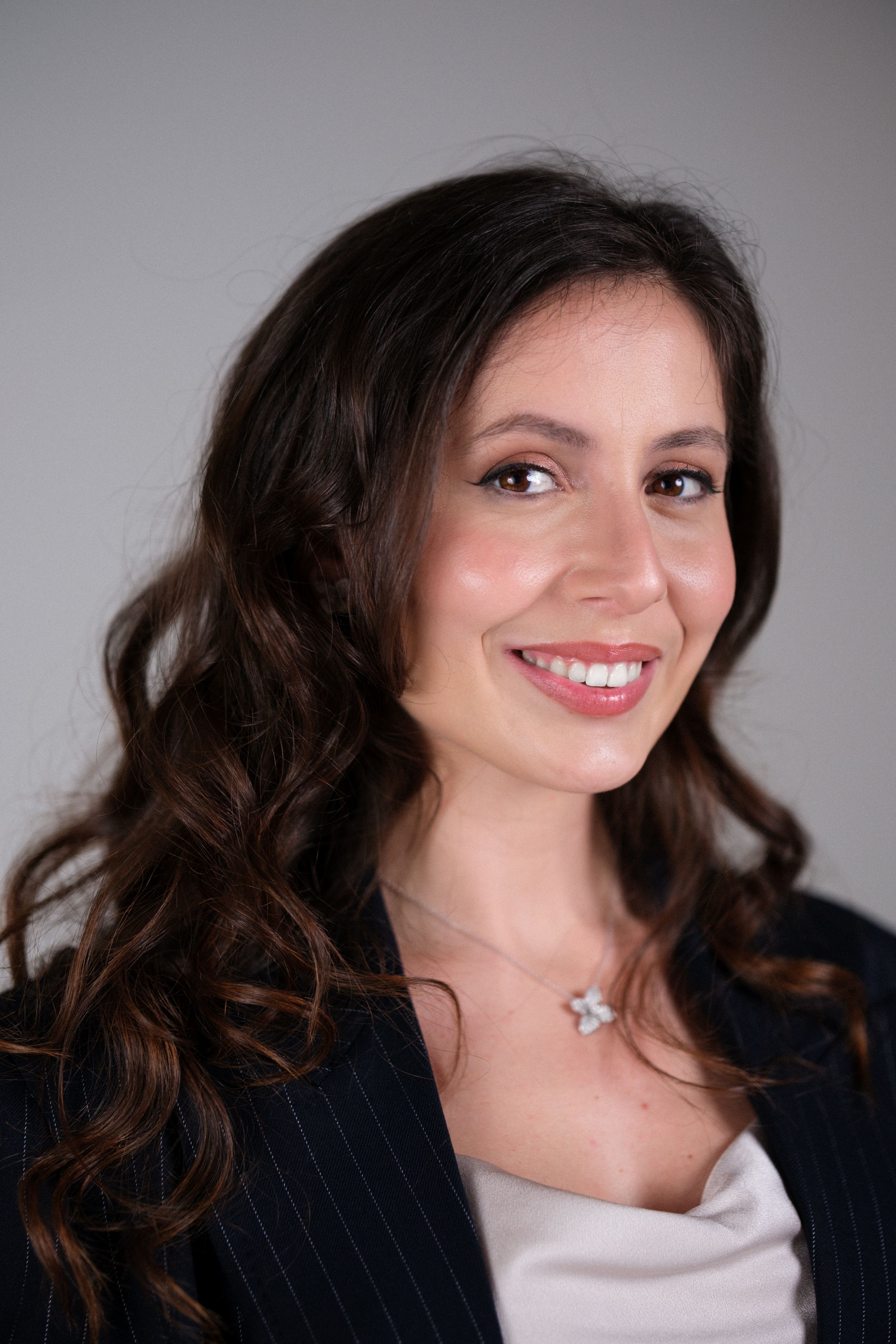 Professional headshots featuring dark blazer and white top with natural styling.