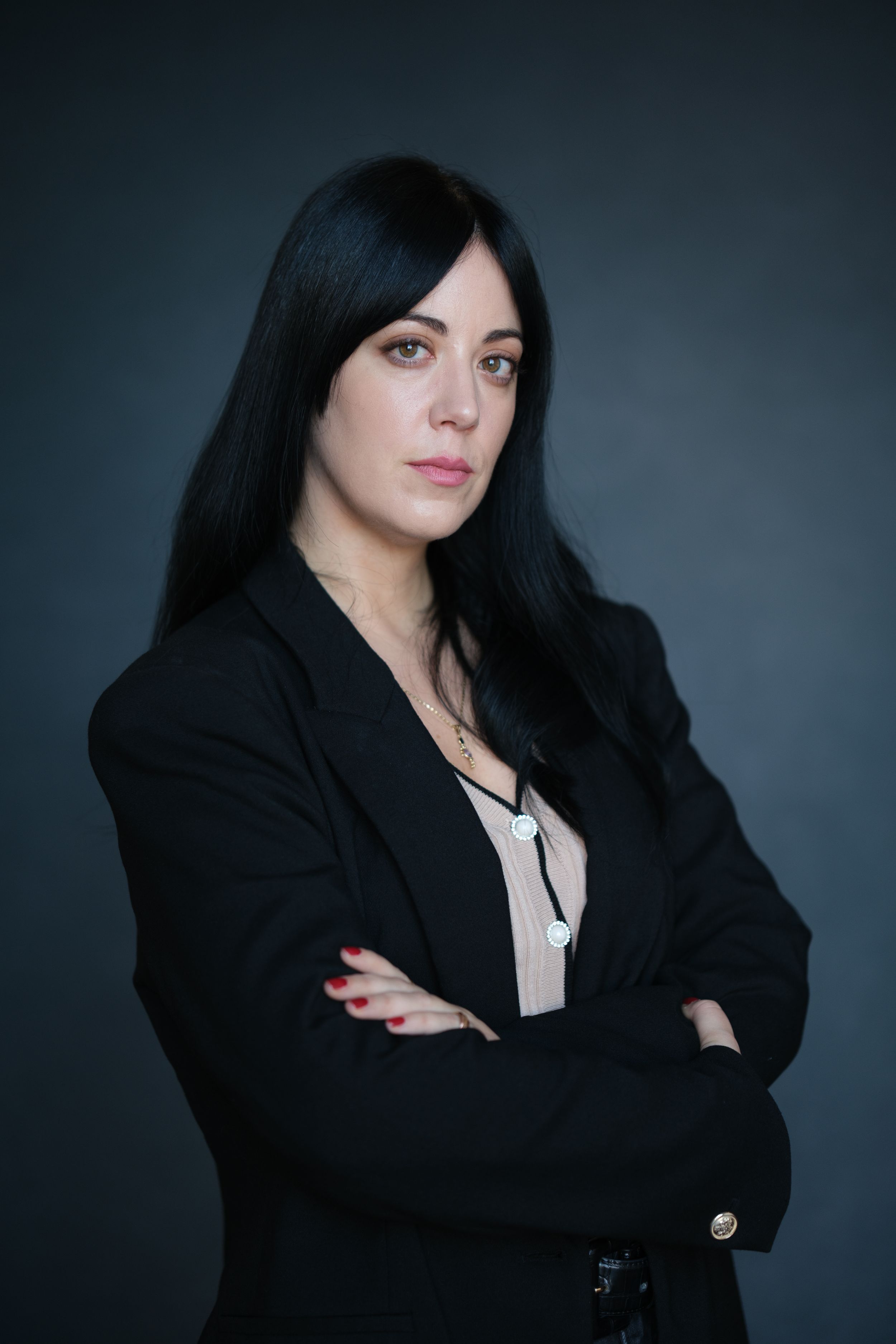 Dramatic portraits of person in black blazer against dark studio background.