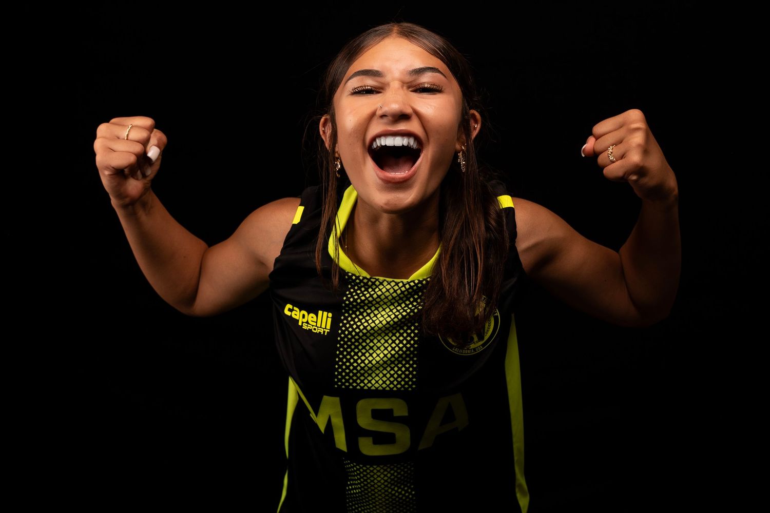 Sports player in neon yellow jersey showing intense celebration expression.