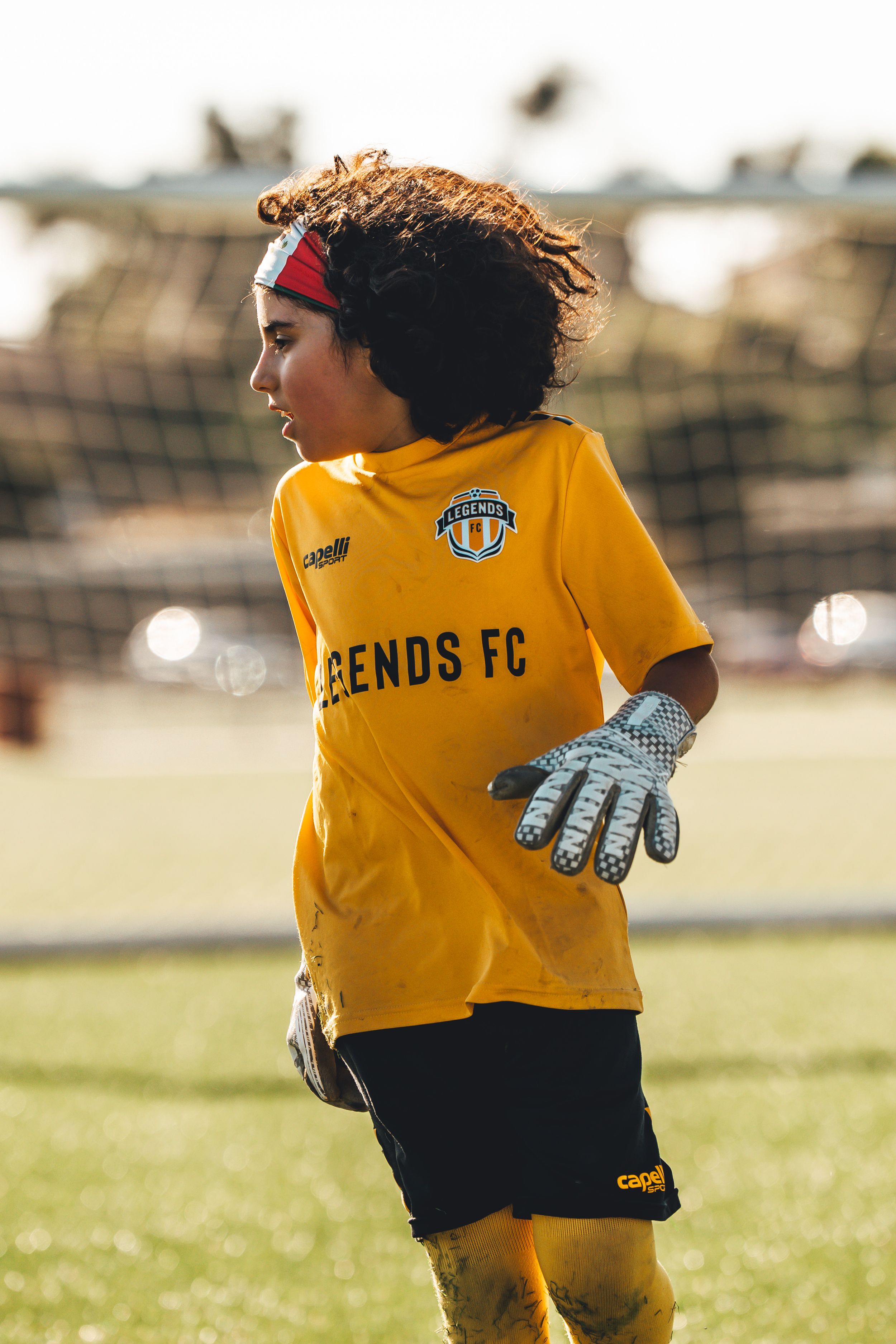 Youth soccer players in yellow jerseys with Legends FC uniforms practicing on field.