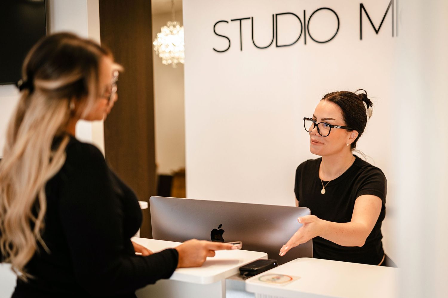 Rebekka på Studio Michelle tar betalt av laserkund i receptionen