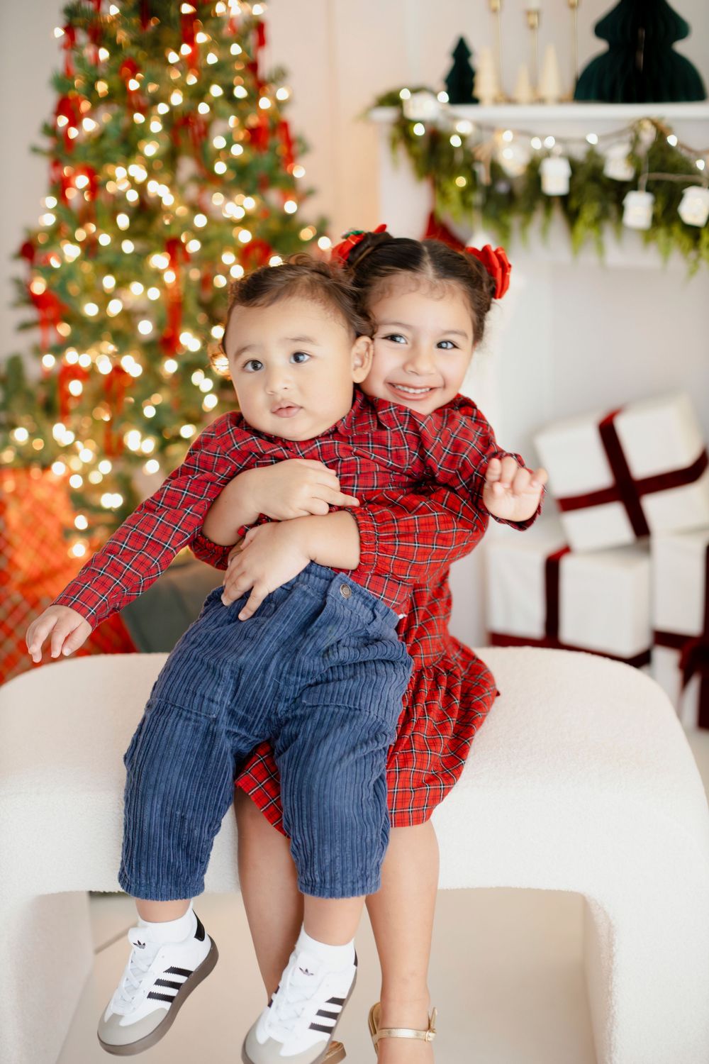 Playful holiday photoshoot sequence showing joyful moments against a festive Christmas backdrop with twinkling lights.