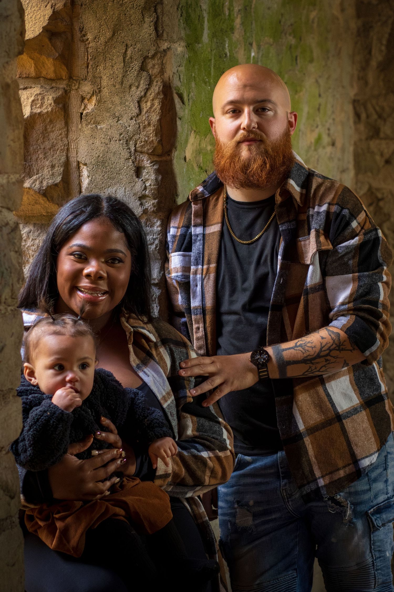 A family of three posing together outdoors, showcasing a warm and intimate family session by Empax Studios.