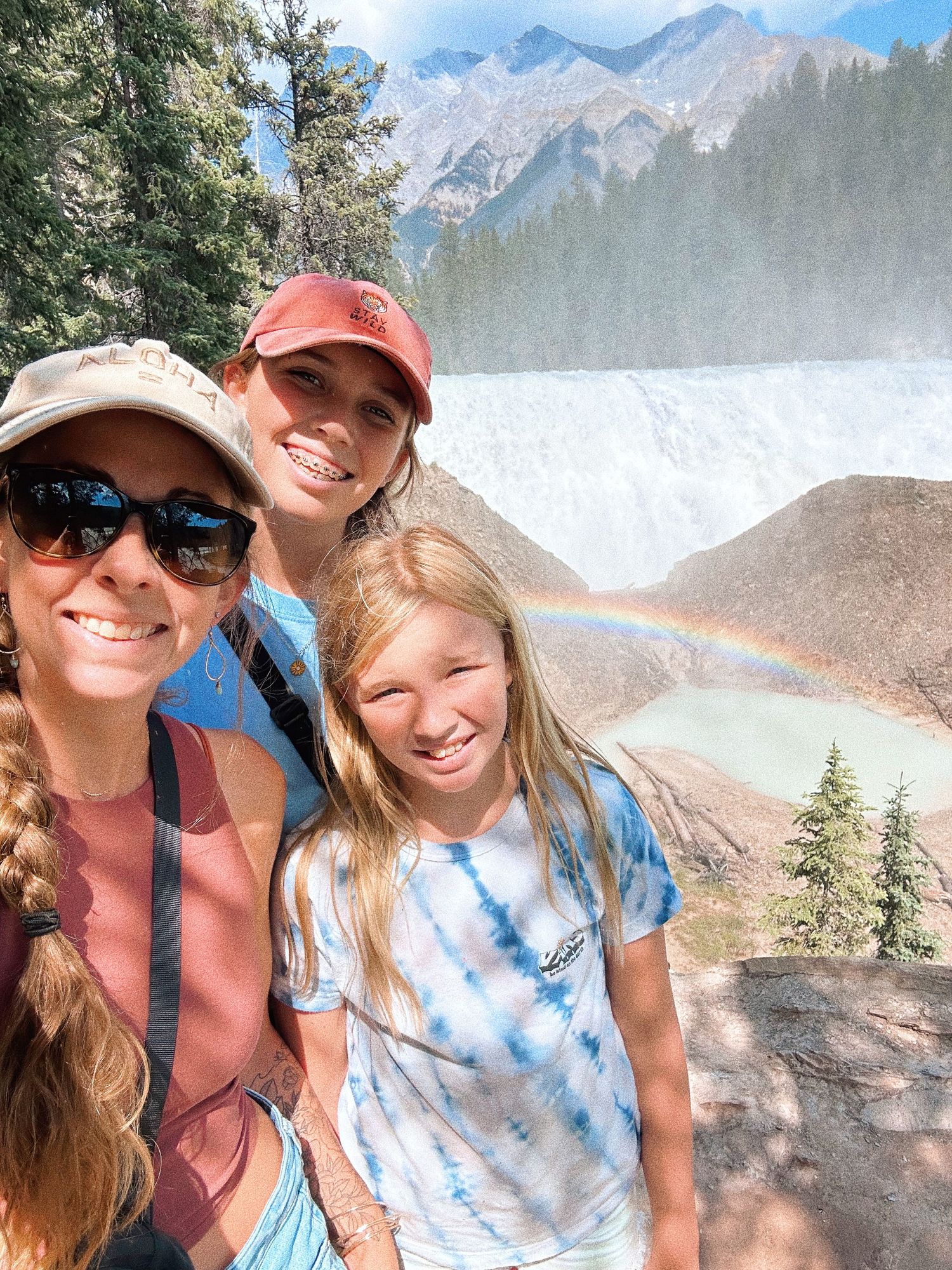 Friends taking selfies with a mountain landscape and rainbow in the background. best hawaii family photographer kihei wailea kaanapali maken