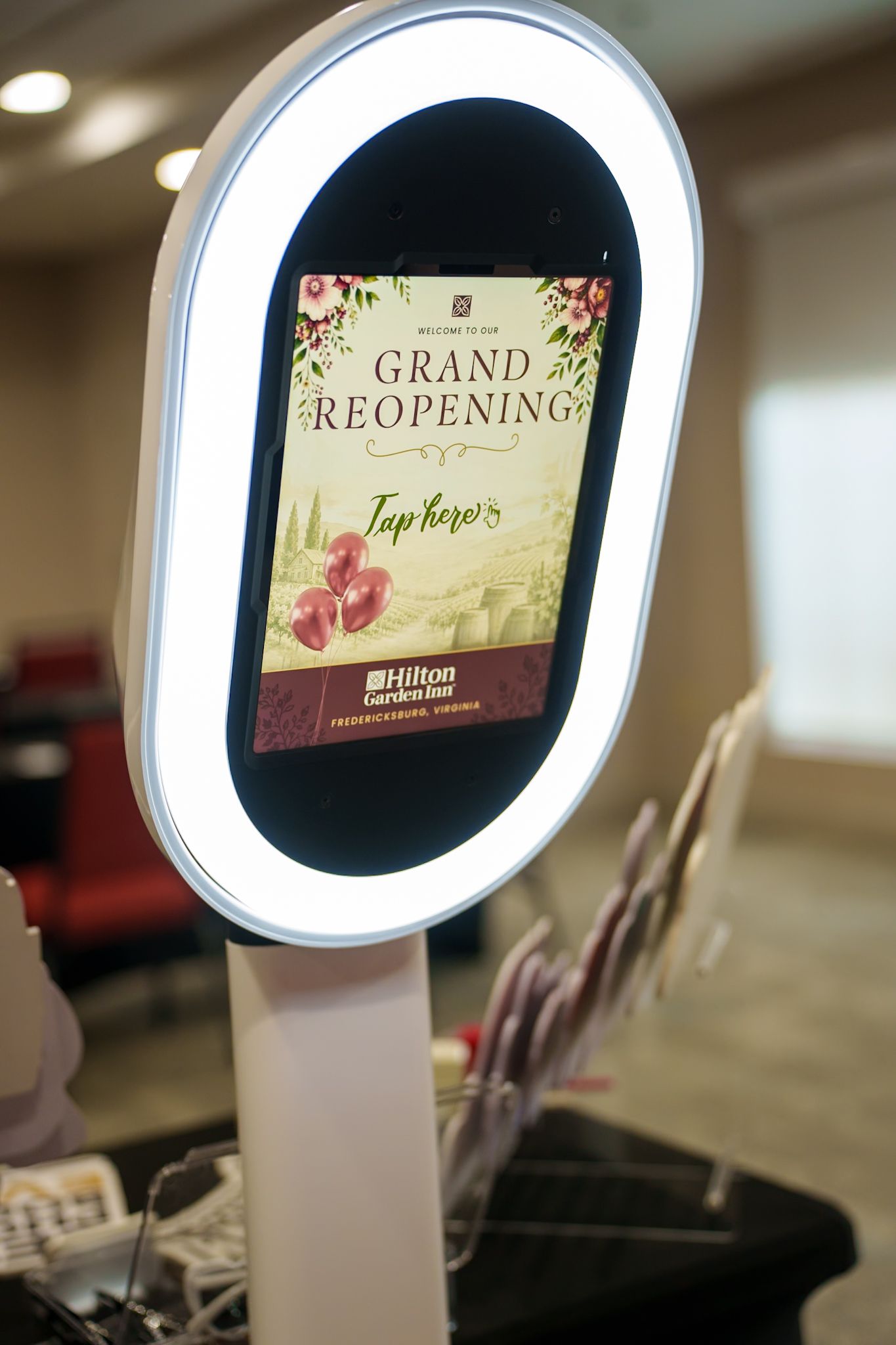 Digital photo booth display with illuminated frame showing interactive interface.