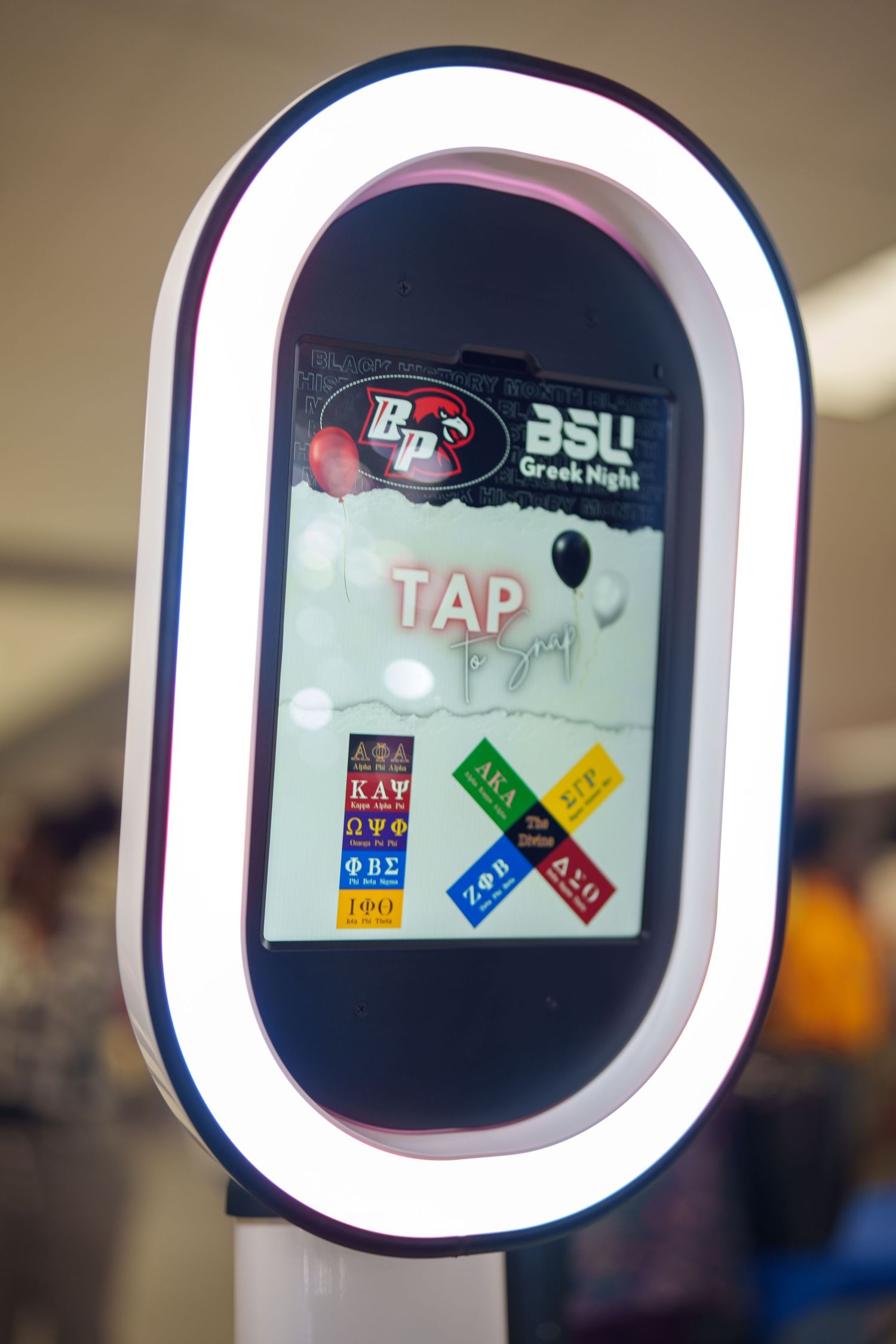 Digital photo booth display with illuminated frame showing interactive interface.