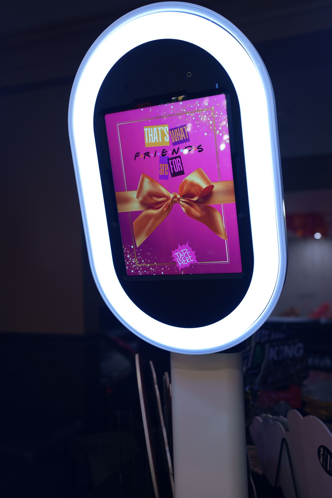 Digital photo booth display with illuminated frame showing interactive interface.