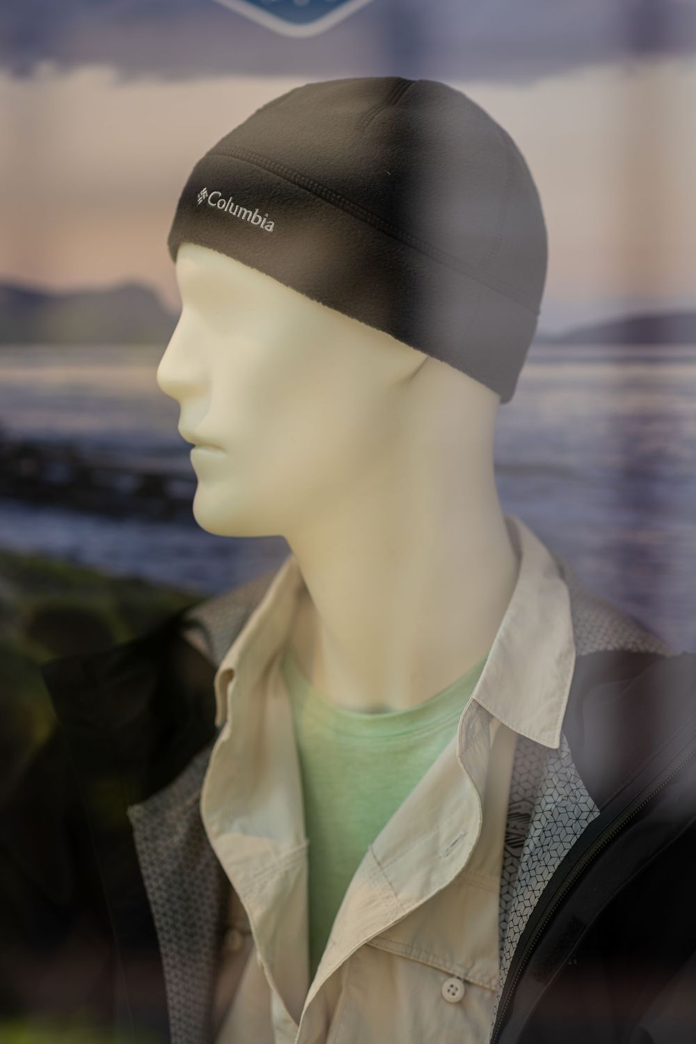 Retail mannequin display featuring casual wear with gray cap and mint green shirt.