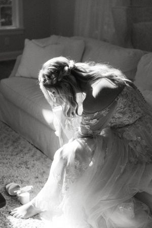 Black and white photo of flowing dress in sunlit room with couch.