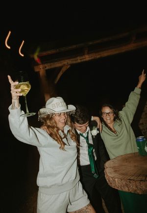 Wedding party celebrating at night with drinks and dancing.