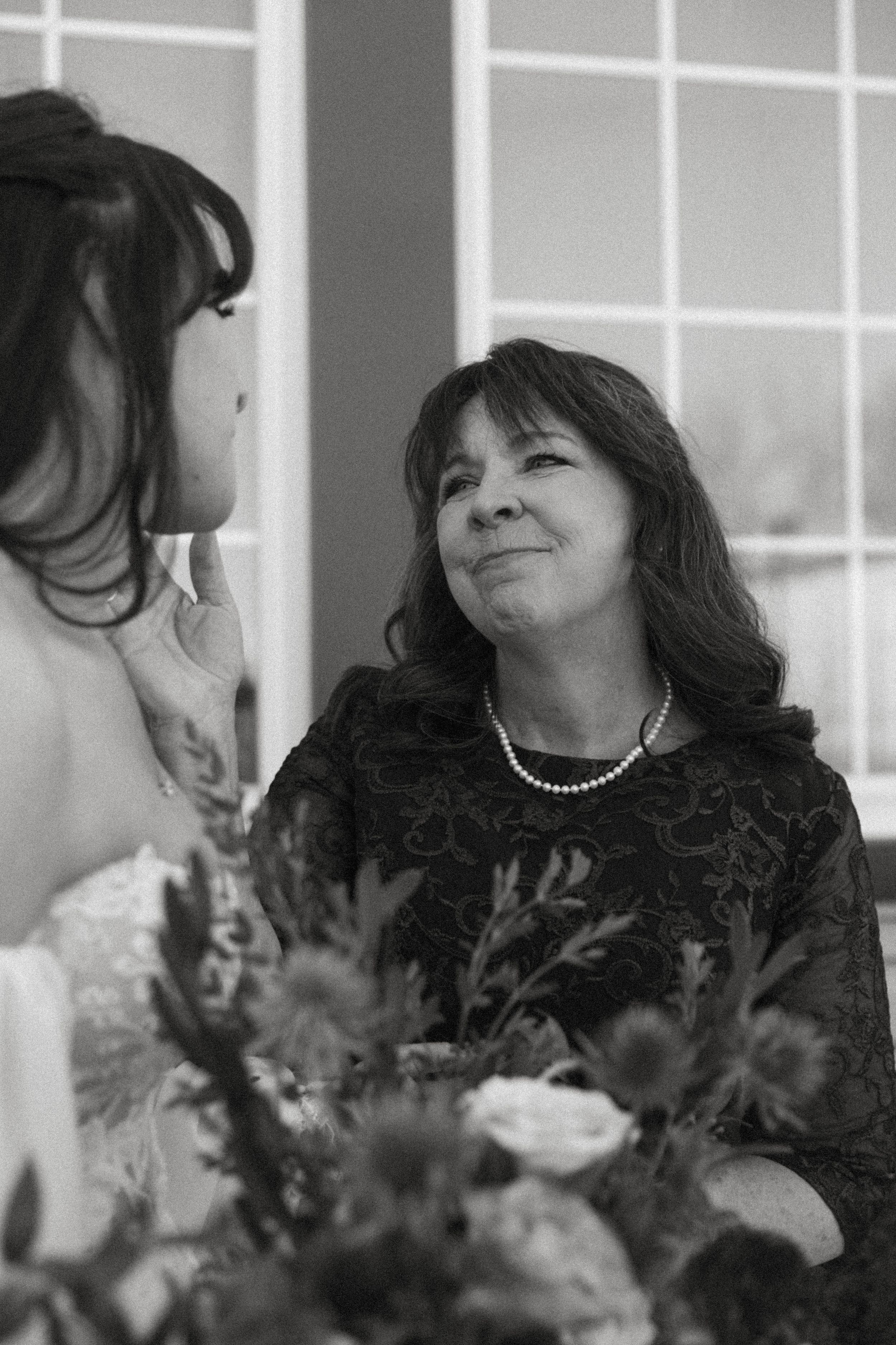 Black and white photo of an emotional moment with floral arrangements in the foreground.