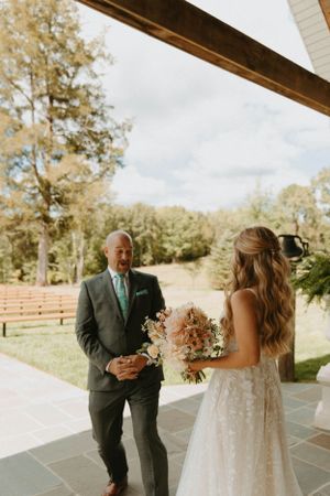An outdoor wedding moment captured on a stone patio with natural scenery.