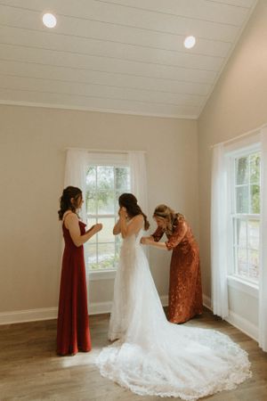 Sunlit bridal preparation room with hardwood floors and large windows.