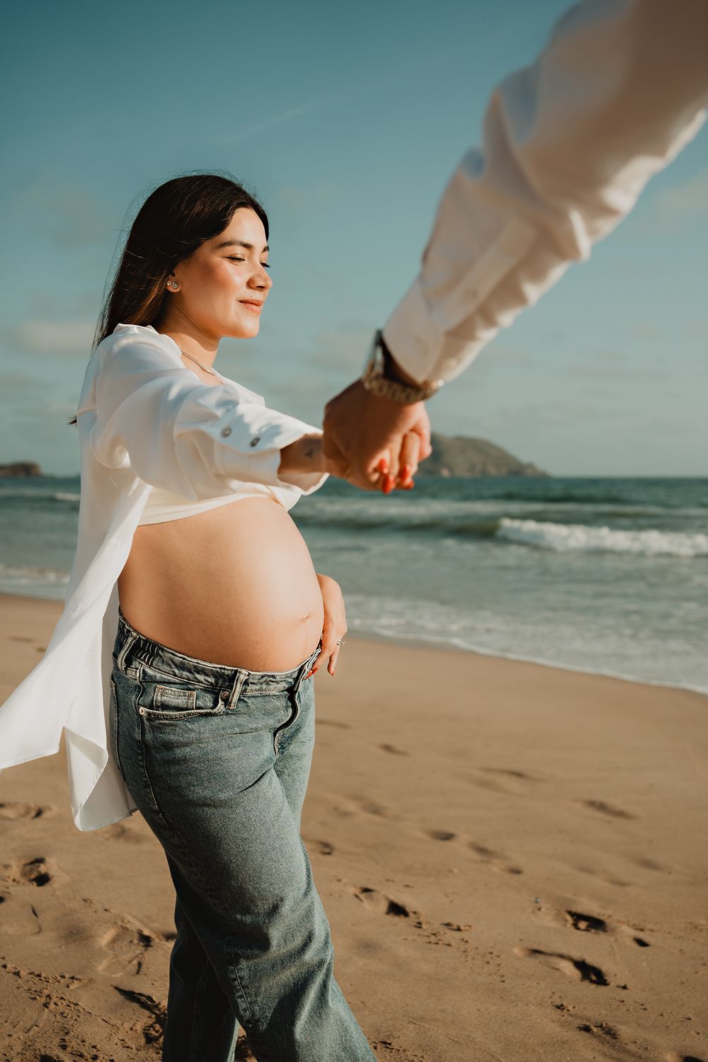 Holding hands, showing off the baby bump, celebrating love and new life in Mazatlán