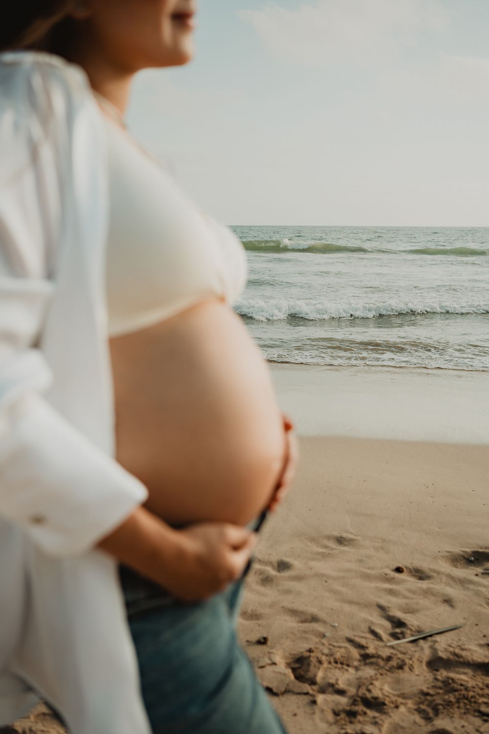 Pregnant wife out of focus, beach and sea in the background, evoking calm in Mazatlán