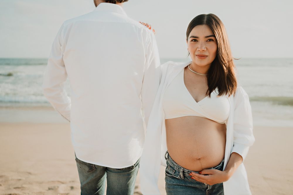 The pregnant wife smiling brightly at the camera, radiating joy during this special time