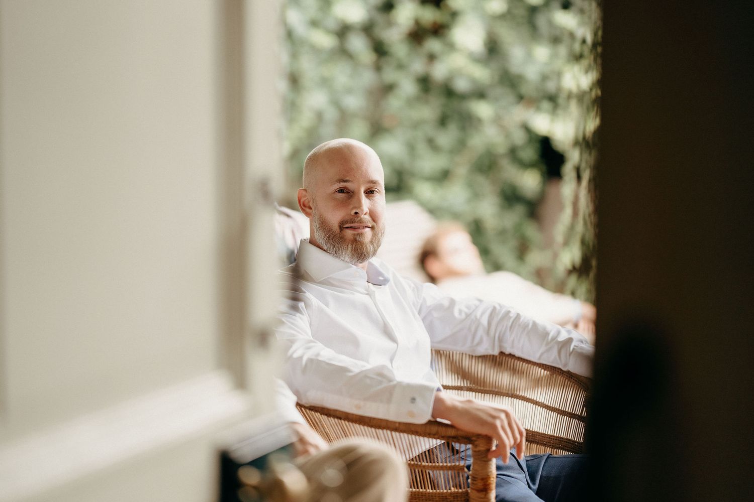 A person in white sits peacefully outdoors in soft natural lighting.