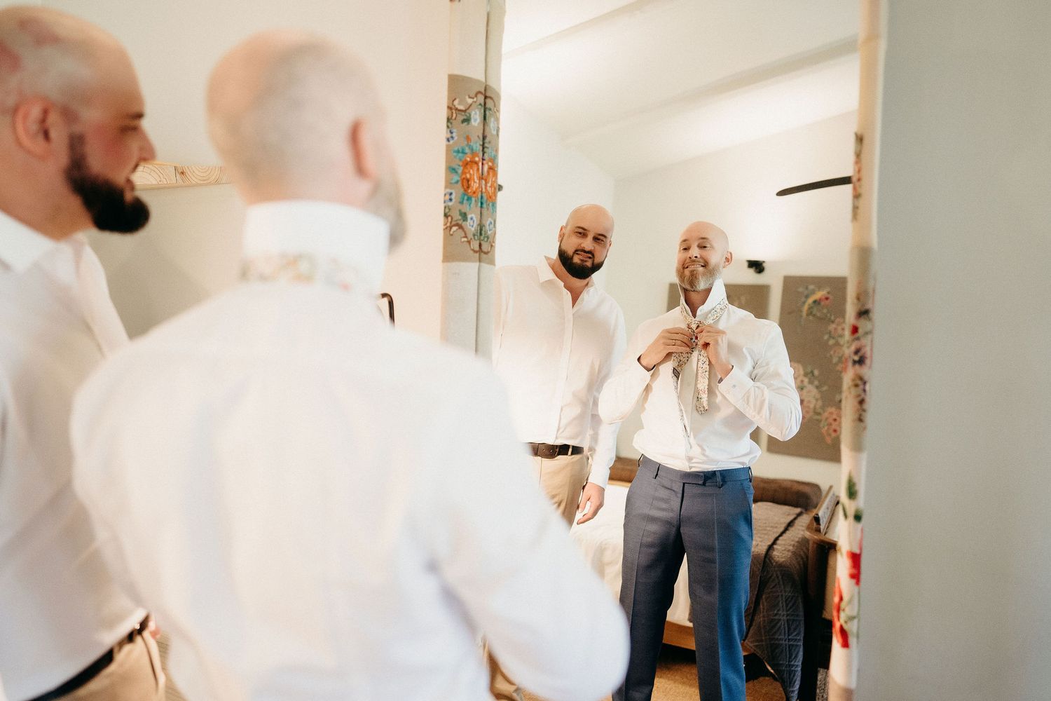 Group of people in white dress shirts getting ready in front of a mirror.