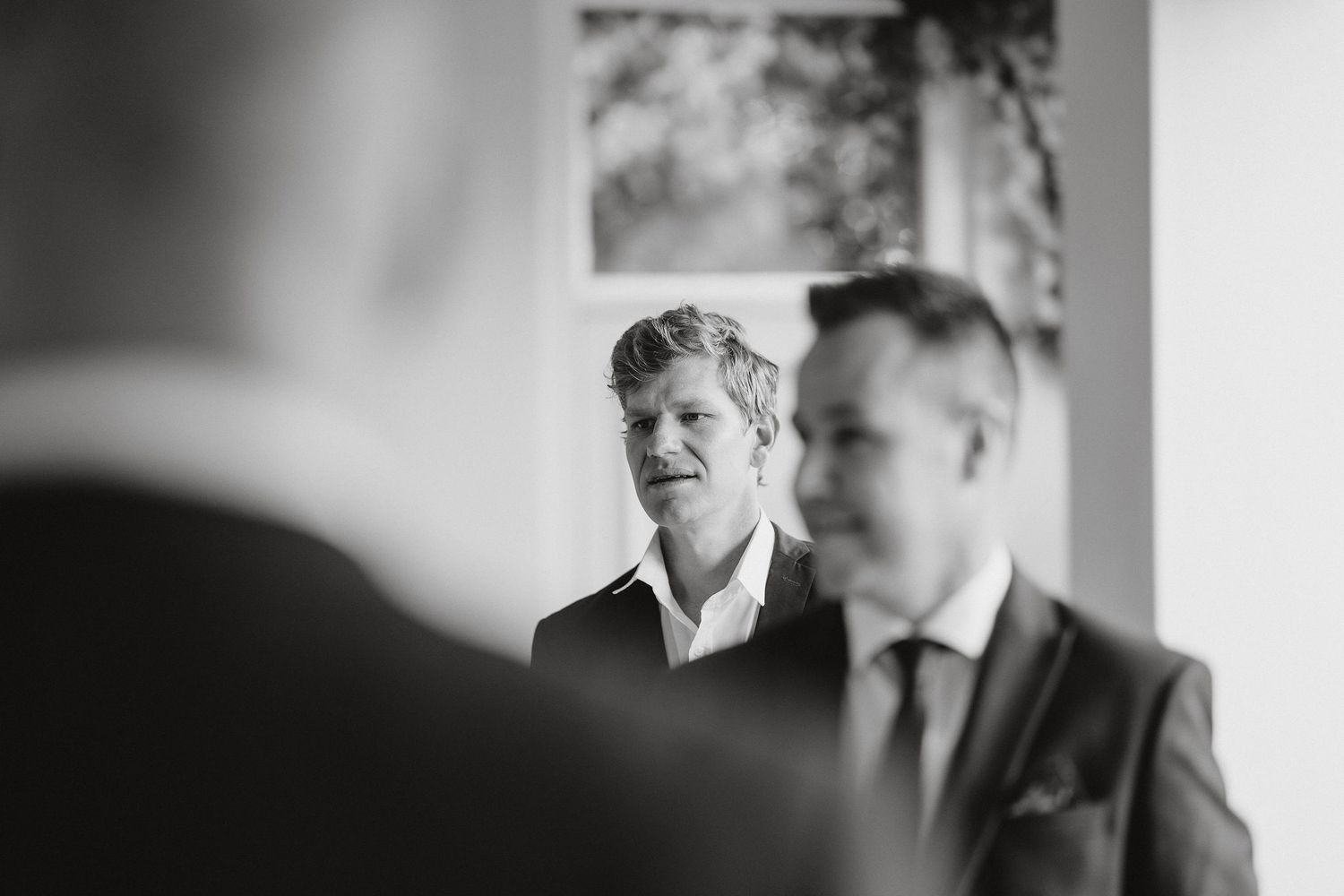 Black and white candid photo capturing emotional moments between people during a celebration.