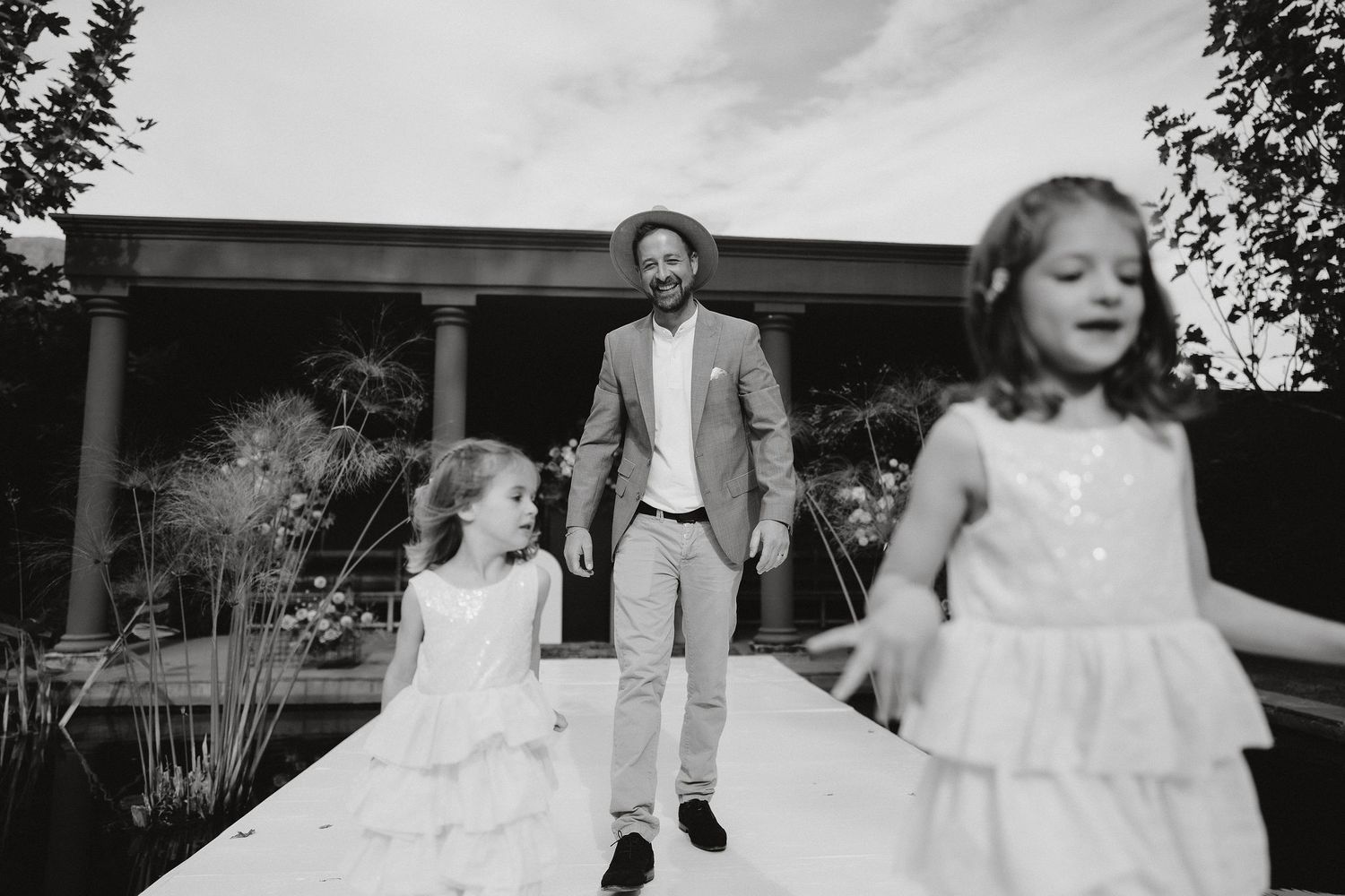 Black and white photo showing a group walking together outdoors on a bright summer day.