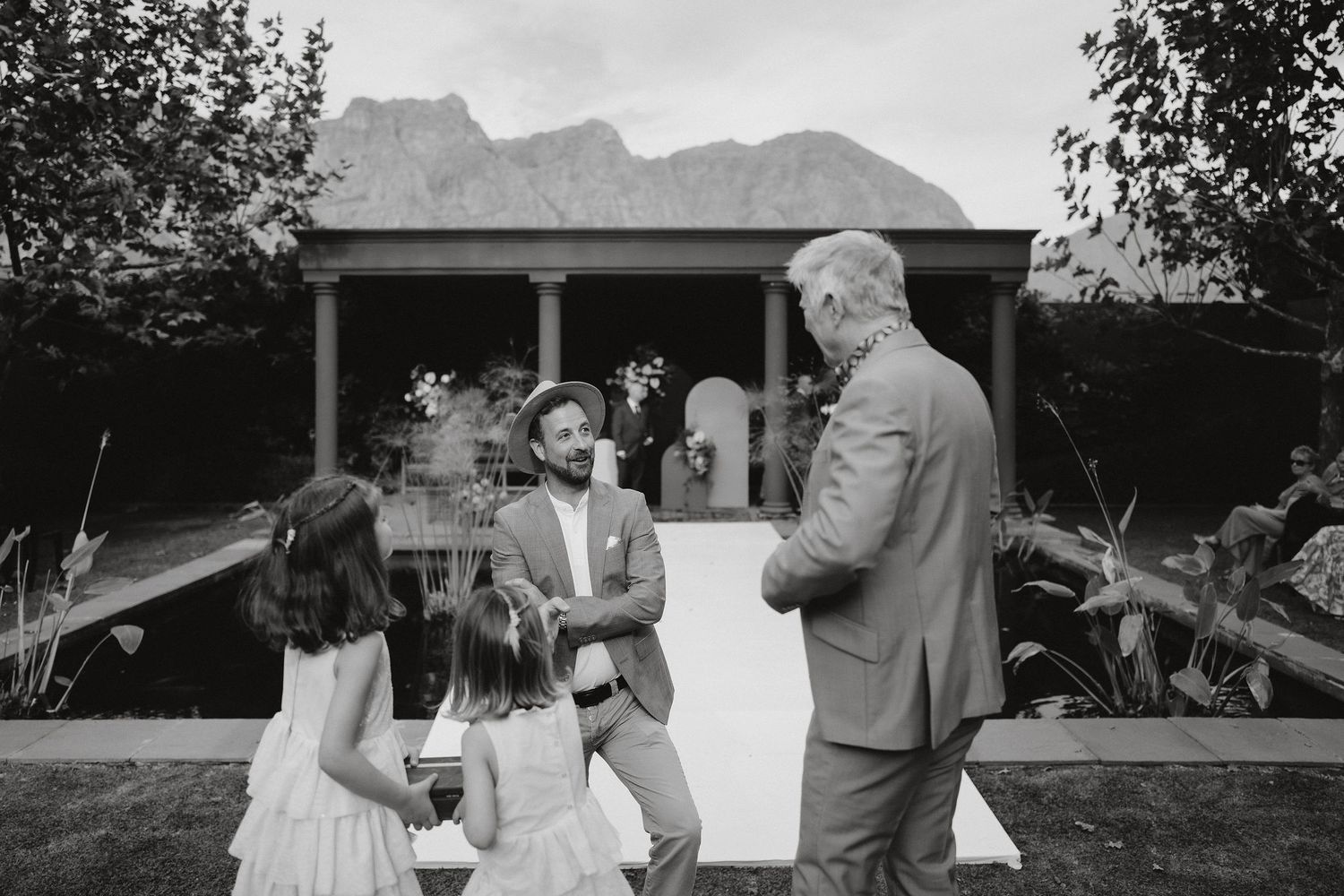 A black and white wedding ceremony moment captured at an outdoor venue with mountain views in the background.